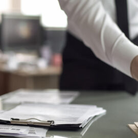 Person sorting through paperwork at a desk while dealing with missing tax documents.