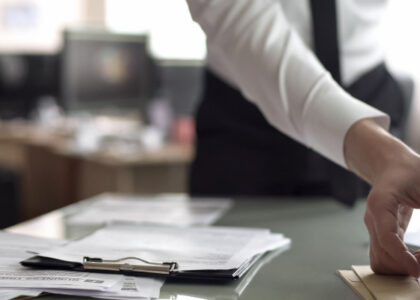 Person sorting through paperwork at a desk while dealing with missing tax documents.